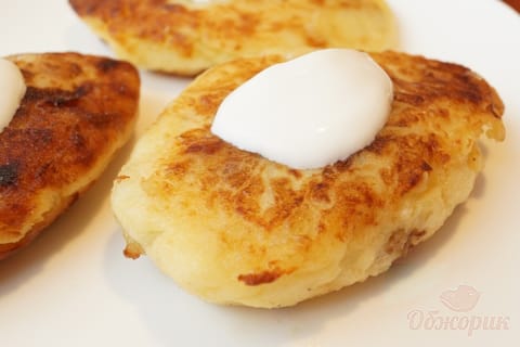 Golden potato zrazy on a plate, one broken open to show the meat filling